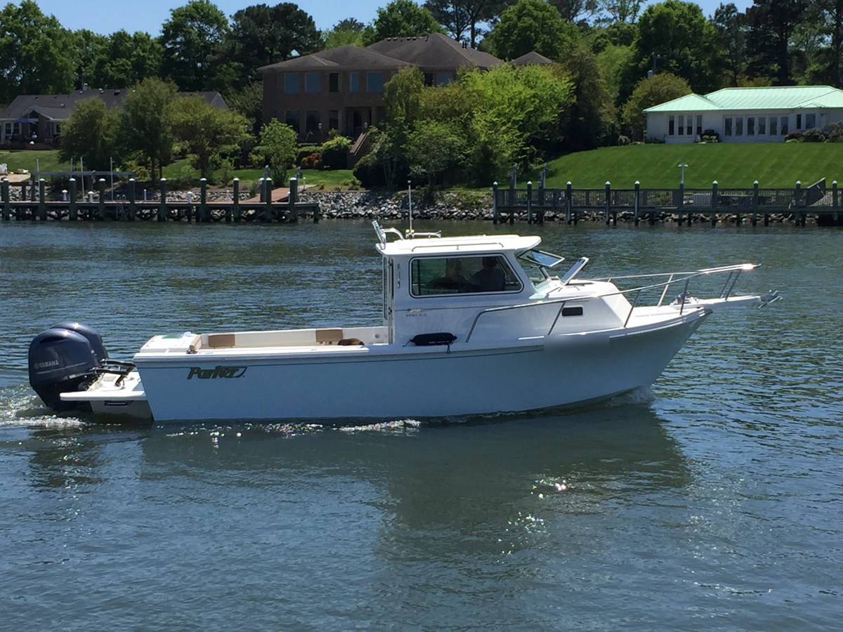 Boat cruising past waterfront homes with private piers and a rip rap shoreline