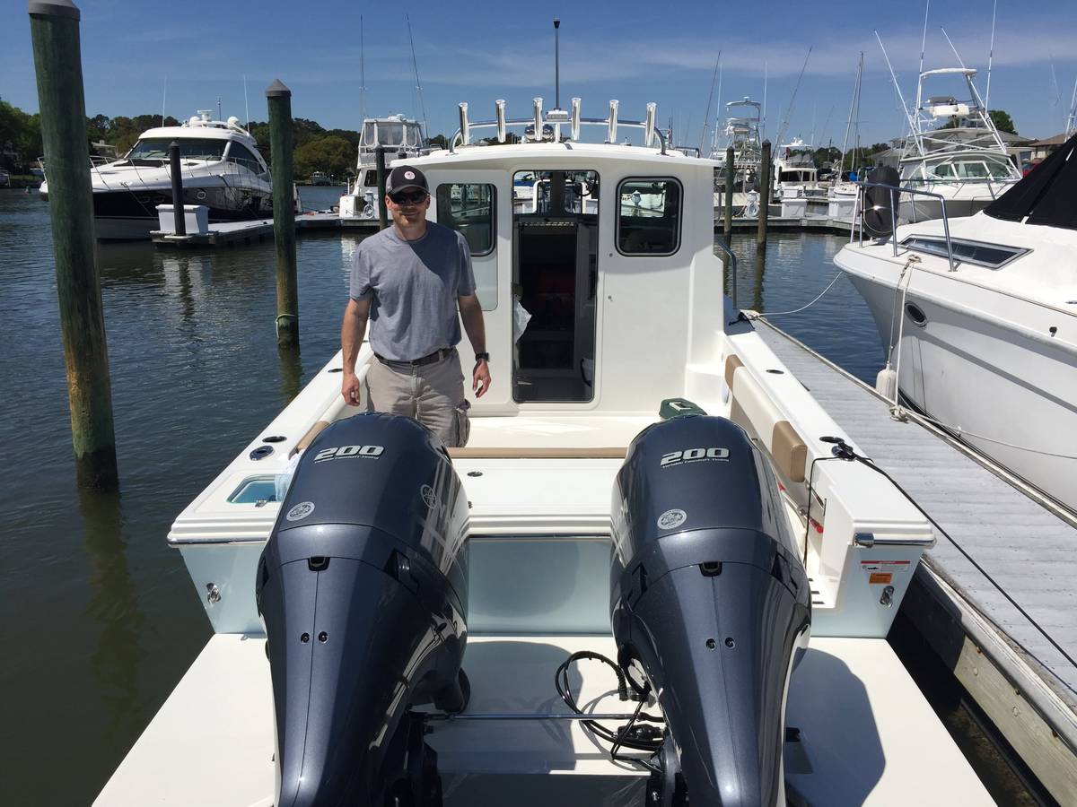 Jon, founder of 757 Waterfront, standing on his boat at a marina slip