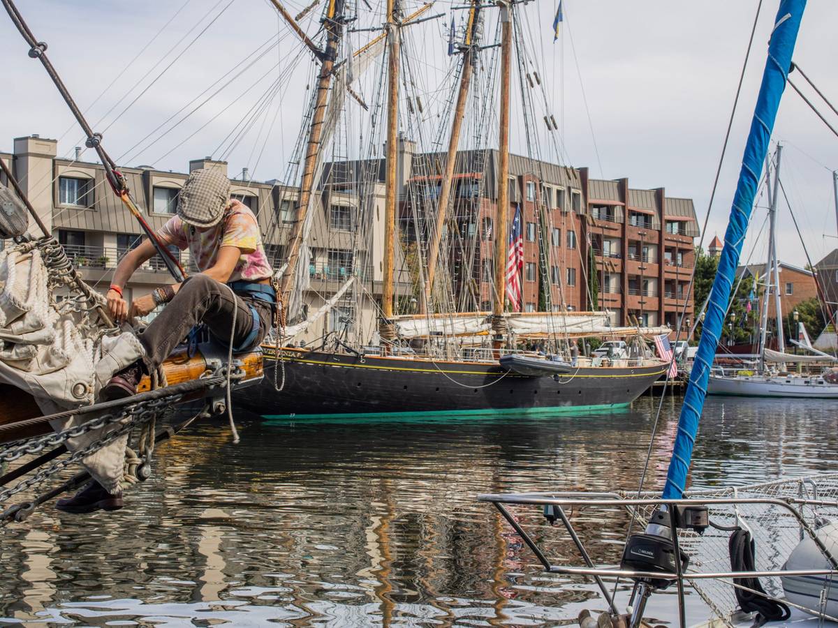 Tall ship schooner docked along the Norfolk waterfront with condominiums behind