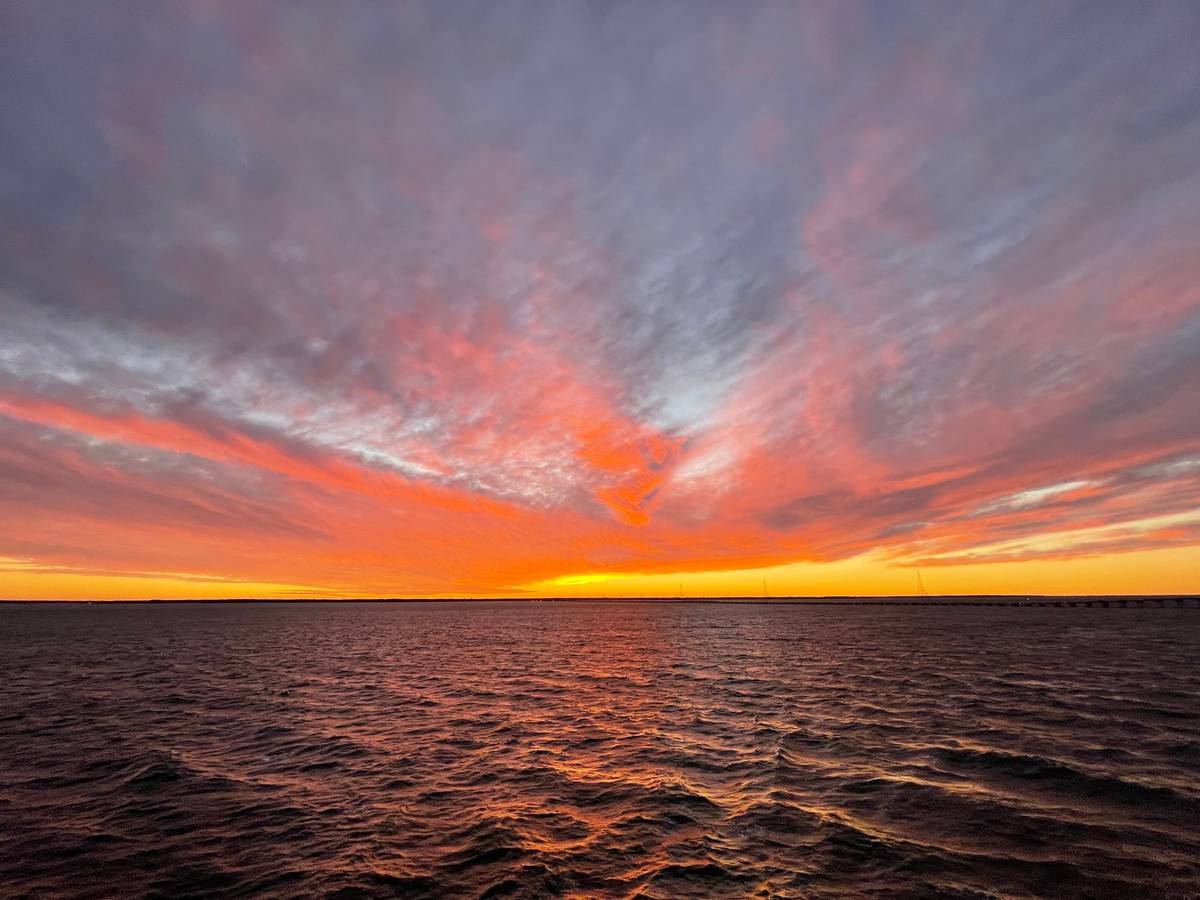 Orange sunset over open water in coastal Virginia